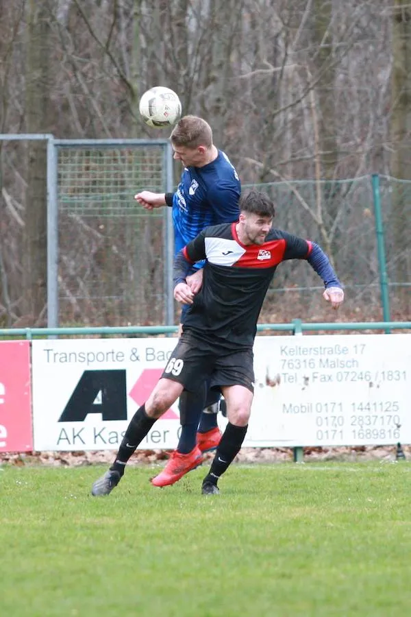 Zwei Fußballspieler, einer köpft den Ball springend