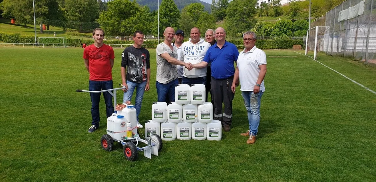 Gruppenfoto mit Farbeimern für Spielfeldmarkierung