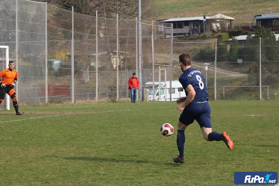 Fußballspieler mit Ball auf Rasen