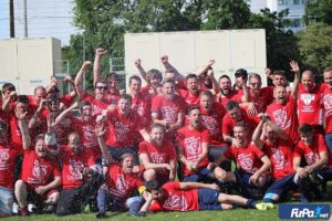 Feierende Fußballmannschaft in roten Fußballtrikot