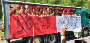 Lastwagen mit feiernden Fußballspielern und Bier